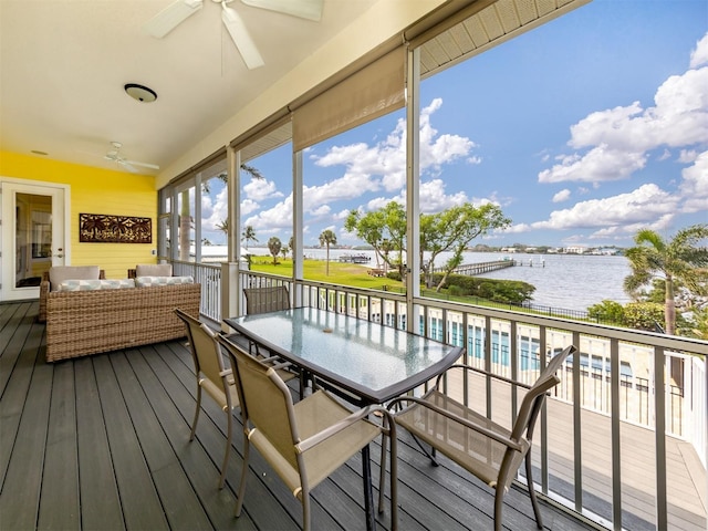 wooden terrace with a water view, outdoor lounge area, and ceiling fan