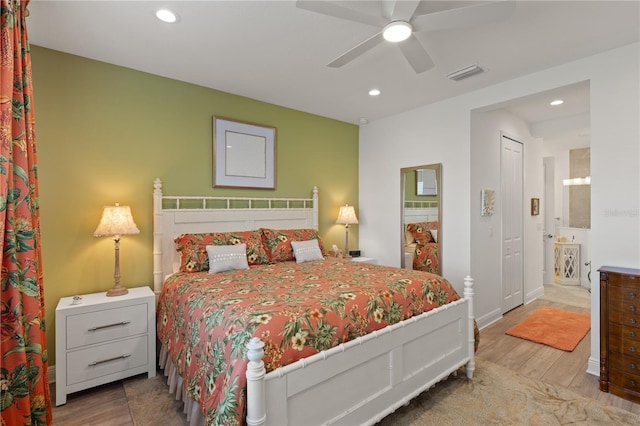 bedroom featuring ceiling fan, ensuite bathroom, and hardwood / wood-style floors