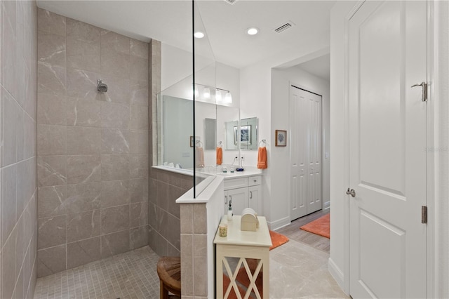 bathroom featuring vanity and tiled shower