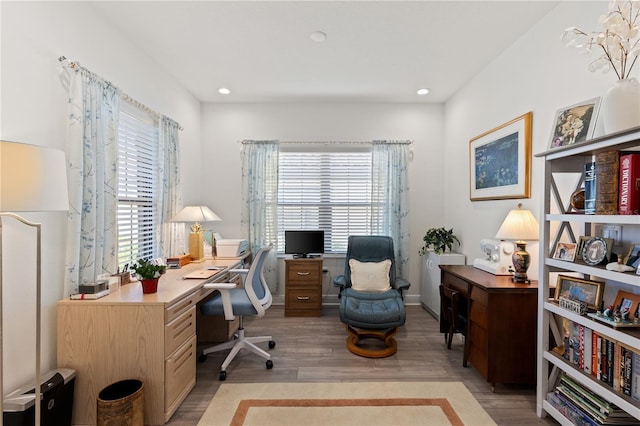 home office with plenty of natural light and light hardwood / wood-style flooring