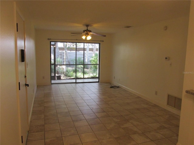 empty room with ceiling fan and light tile patterned floors