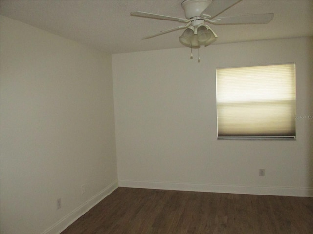 spare room featuring dark wood-type flooring and ceiling fan