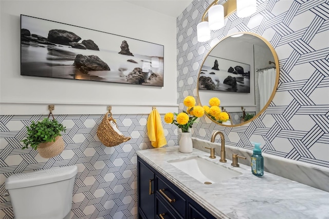 bathroom with vanity, tile walls, and toilet