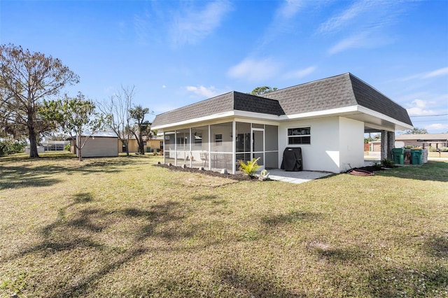 rear view of house with a sunroom and a yard