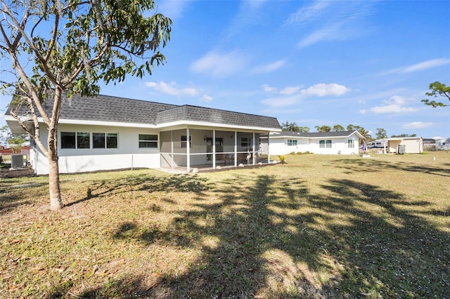 back of property with cooling unit, a lawn, and a sunroom