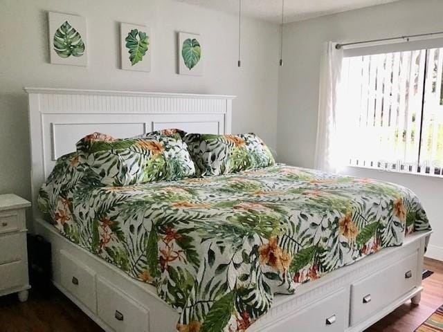 bedroom with dark hardwood / wood-style flooring