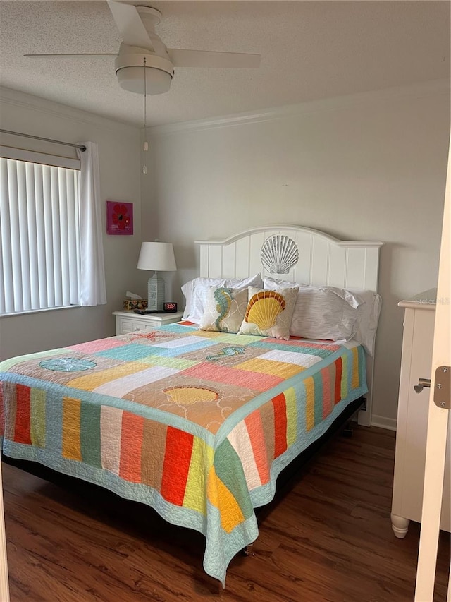 bedroom featuring crown molding, a textured ceiling, dark hardwood / wood-style floors, and ceiling fan