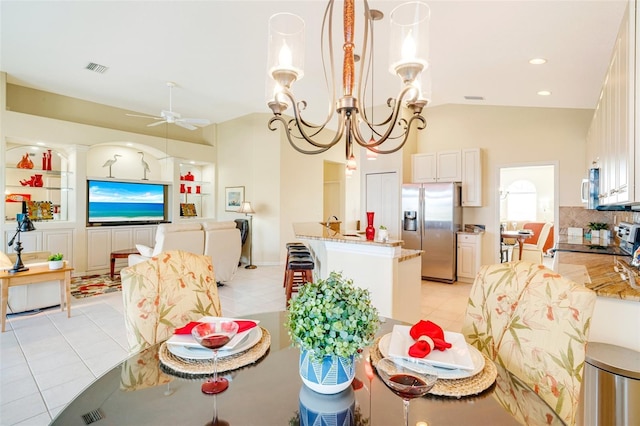 tiled dining room with ceiling fan with notable chandelier, vaulted ceiling, and built in features