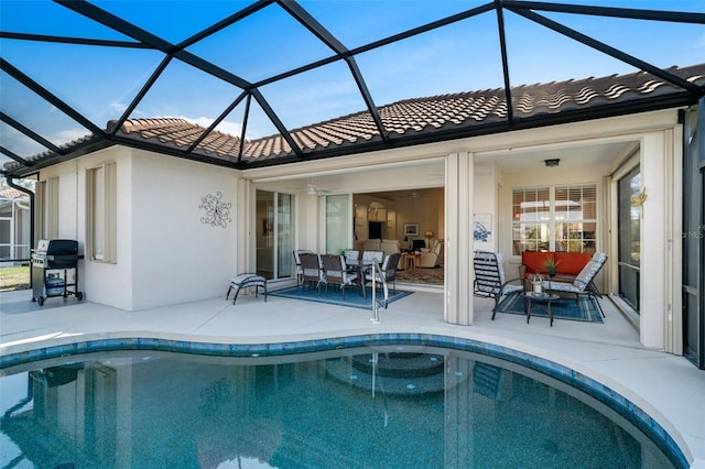 view of pool with ceiling fan, a grill, a patio, and glass enclosure