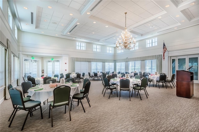 carpeted dining space featuring french doors, plenty of natural light, coffered ceiling, and an inviting chandelier