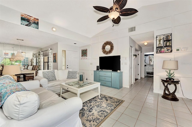 living room featuring ceiling fan, lofted ceiling, and light tile patterned floors