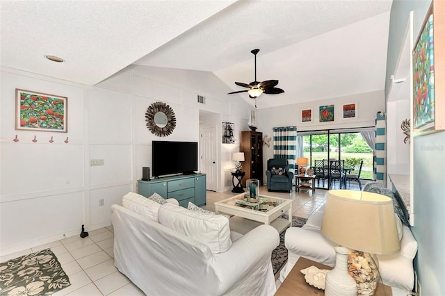 tiled living room featuring ceiling fan, lofted ceiling, and a textured ceiling