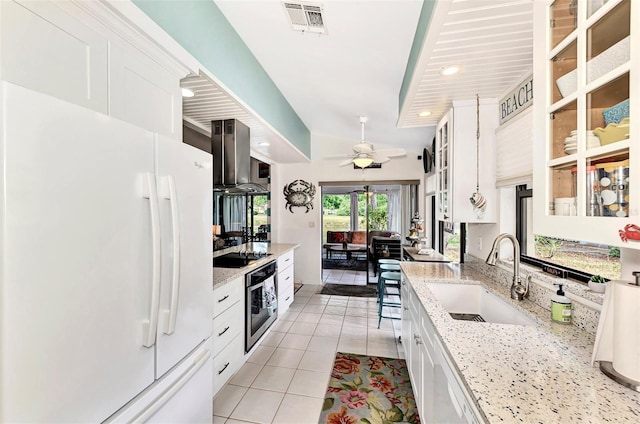 kitchen with white appliances, light stone countertops, sink, and white cabinets