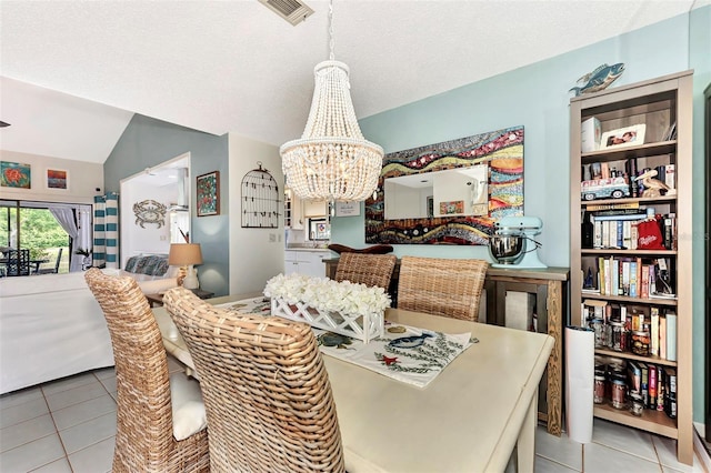 tiled dining room with lofted ceiling, a textured ceiling, and an inviting chandelier