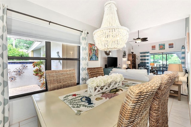 dining room featuring ceiling fan with notable chandelier, vaulted ceiling, and light tile patterned floors