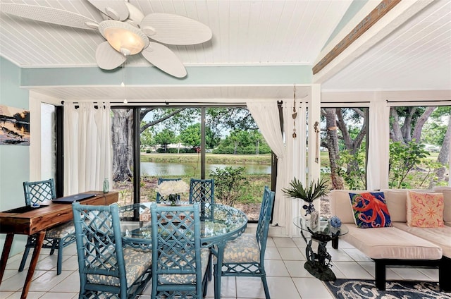 sunroom featuring a water view, ceiling fan, and beamed ceiling