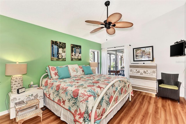 bedroom with hardwood / wood-style flooring, vaulted ceiling, and access to exterior