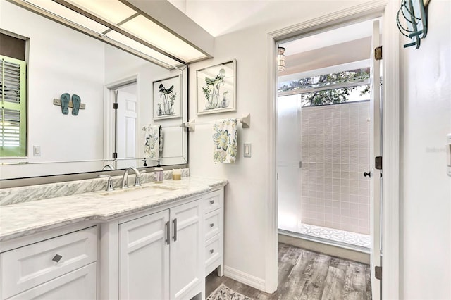 bathroom with vanity, wood-type flooring, and tiled shower