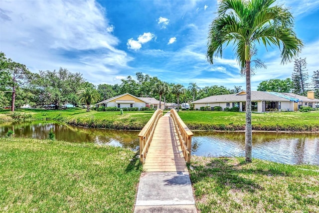 dock area with a lawn and a water view