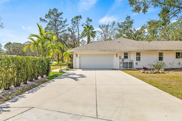 single story home with cooling unit and a garage