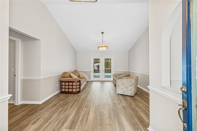 unfurnished room with lofted ceiling, french doors, and light wood-type flooring