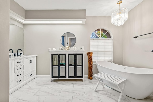 bathroom with vanity, a notable chandelier, and a tub