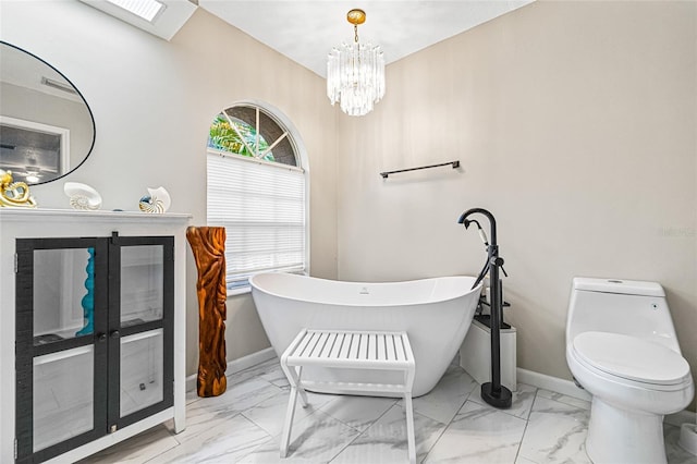 bathroom featuring a tub, an inviting chandelier, and toilet