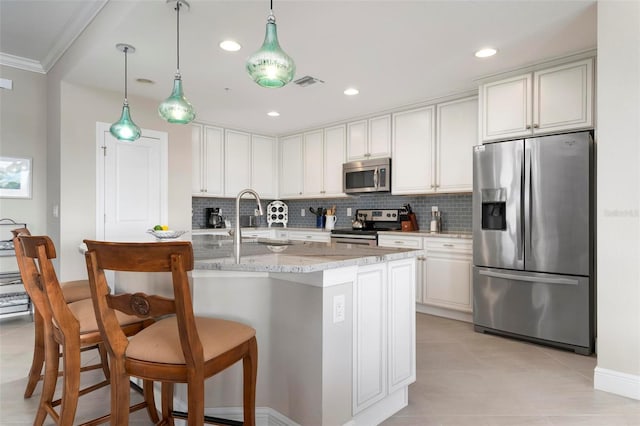 kitchen featuring tasteful backsplash, white cabinetry, sink, light stone counters, and stainless steel appliances