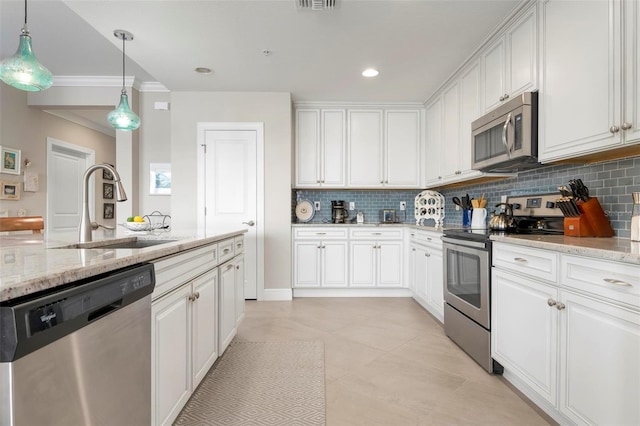 kitchen with white cabinetry, appliances with stainless steel finishes, light stone countertops, and sink