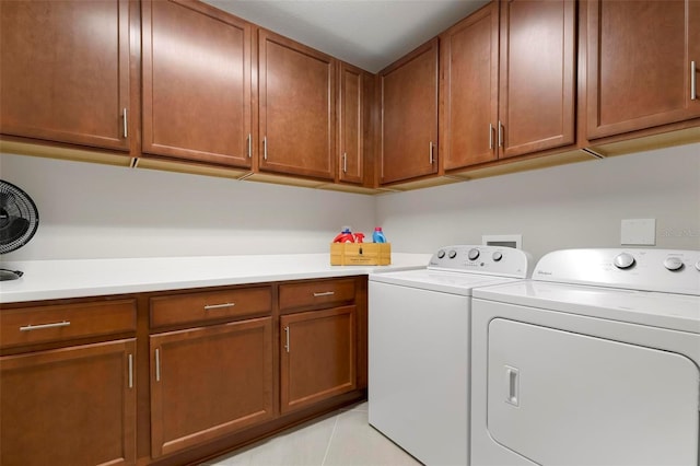 laundry area featuring cabinets, washer and dryer, and light tile patterned flooring