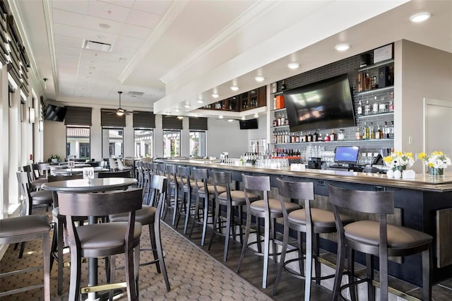 bar with hardwood / wood-style flooring, ornamental molding, and ceiling fan