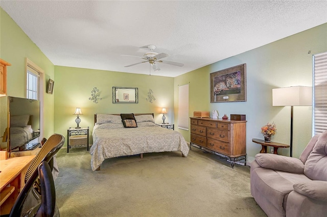 carpeted bedroom with ceiling fan and a textured ceiling