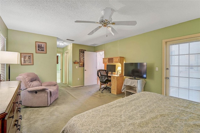 bedroom featuring ceiling fan, light colored carpet, and a textured ceiling