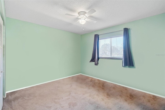 carpeted empty room featuring ceiling fan and a textured ceiling