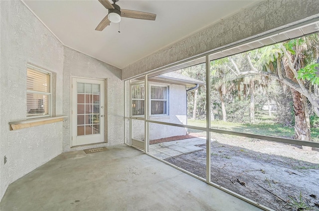 unfurnished sunroom featuring ceiling fan and vaulted ceiling