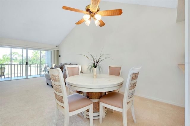 carpeted dining space featuring vaulted ceiling and ceiling fan