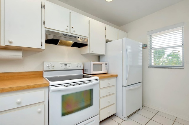 kitchen featuring light tile patterned floors, white cabinets, and white appliances