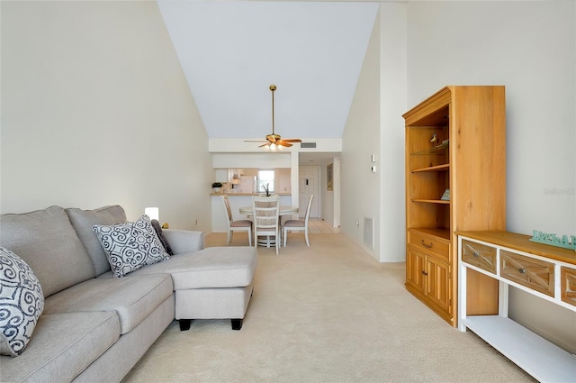 carpeted living room with high vaulted ceiling and ceiling fan