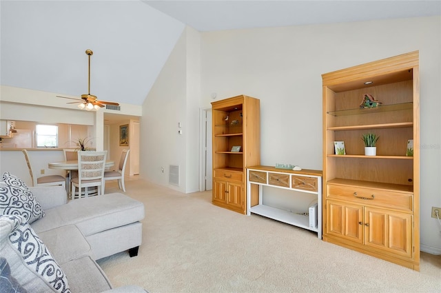 carpeted living room with high vaulted ceiling and ceiling fan