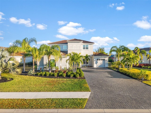 mediterranean / spanish house featuring a garage and a front yard