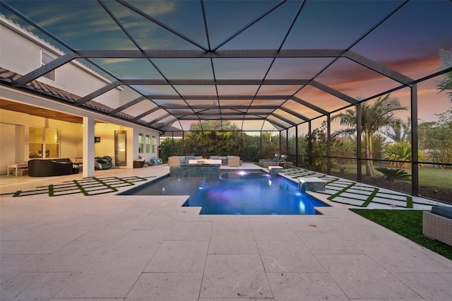 pool at dusk with pool water feature, a lanai, and a patio