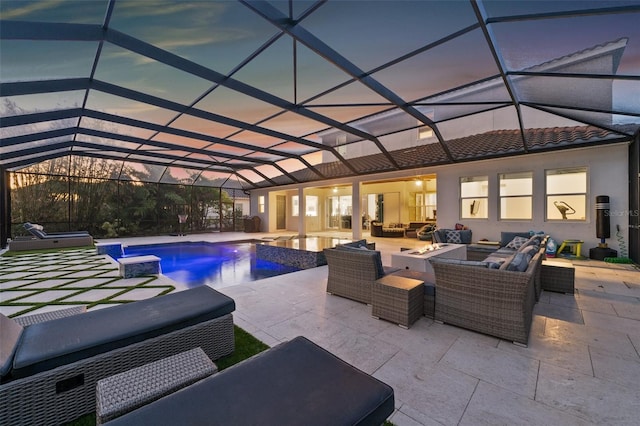 pool at dusk featuring a patio, an outdoor hangout area, glass enclosure, and a jacuzzi