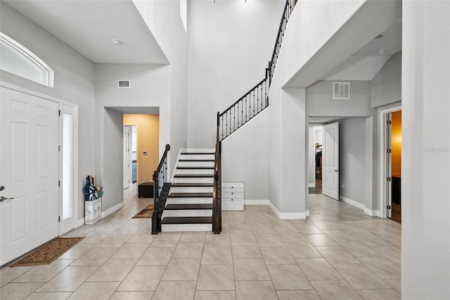 tiled entrance foyer with a towering ceiling