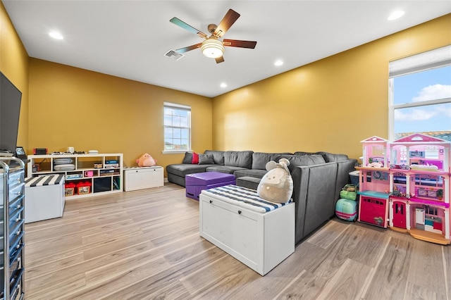 living room with ceiling fan and light wood-type flooring