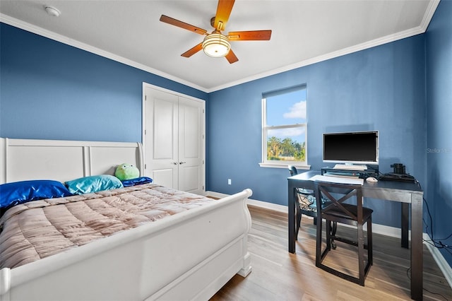 bedroom featuring ornamental molding, a closet, ceiling fan, and light wood-type flooring