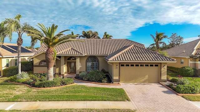 mediterranean / spanish-style house with a garage and a front yard