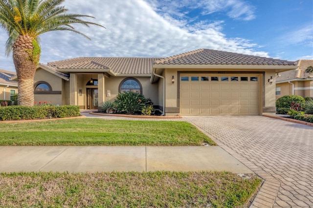 mediterranean / spanish house featuring a garage and a front lawn