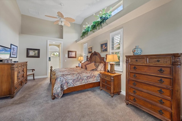 carpeted bedroom with ceiling fan and high vaulted ceiling