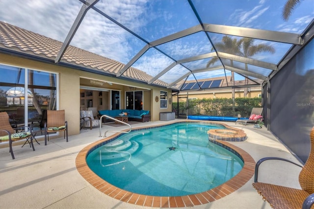 view of pool with an outdoor hangout area, a patio area, and glass enclosure