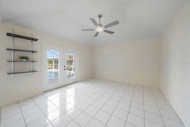 tiled empty room with french doors, ceiling fan, and vaulted ceiling